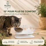Chat mangeant dans une gamelle surélevée inclinée à 15°, favorisant une posture plus naturelle et confortable. bol double transparent, support blanc. Plusieurs coloris aux choix.